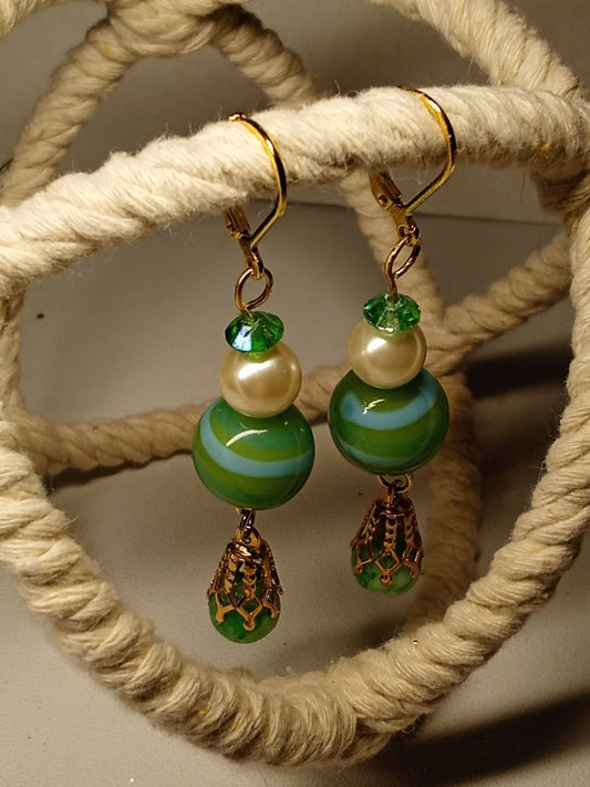 Dangle earrings with soft green beads with blue stripes.