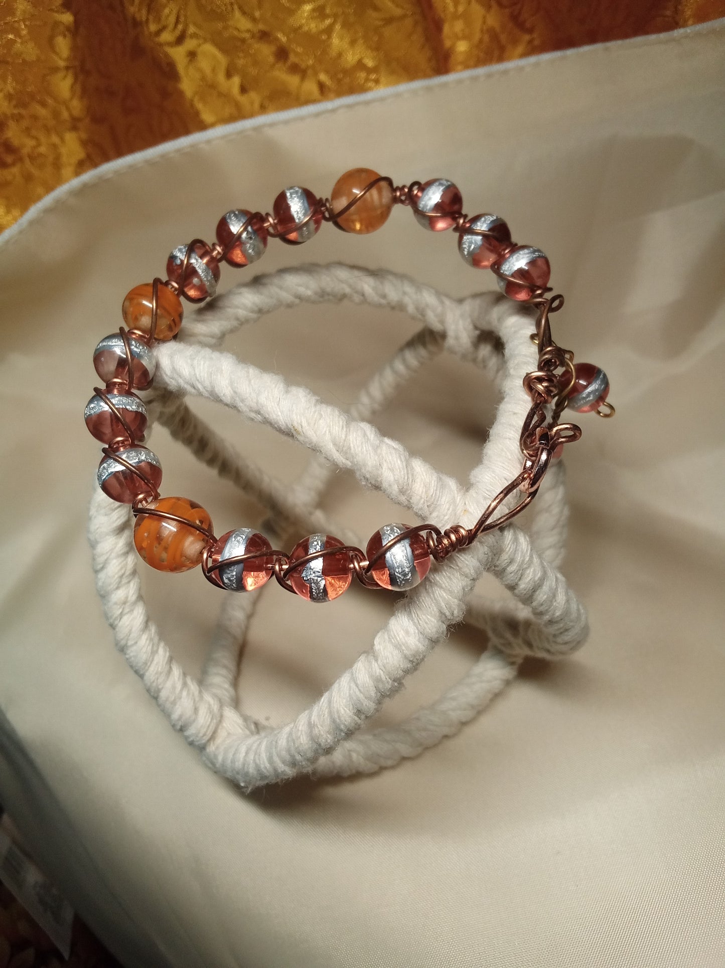 Copper wire wrapped orange/silver beaded bracelet.