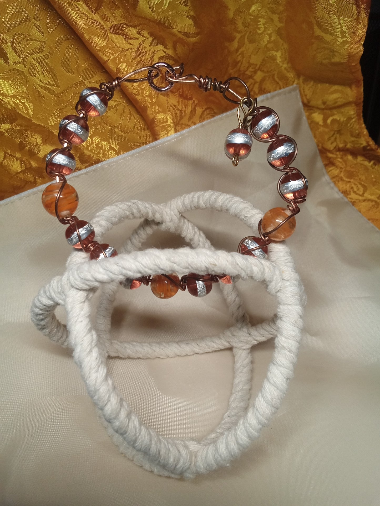 Copper wire wrapped orange/silver beaded bracelet.