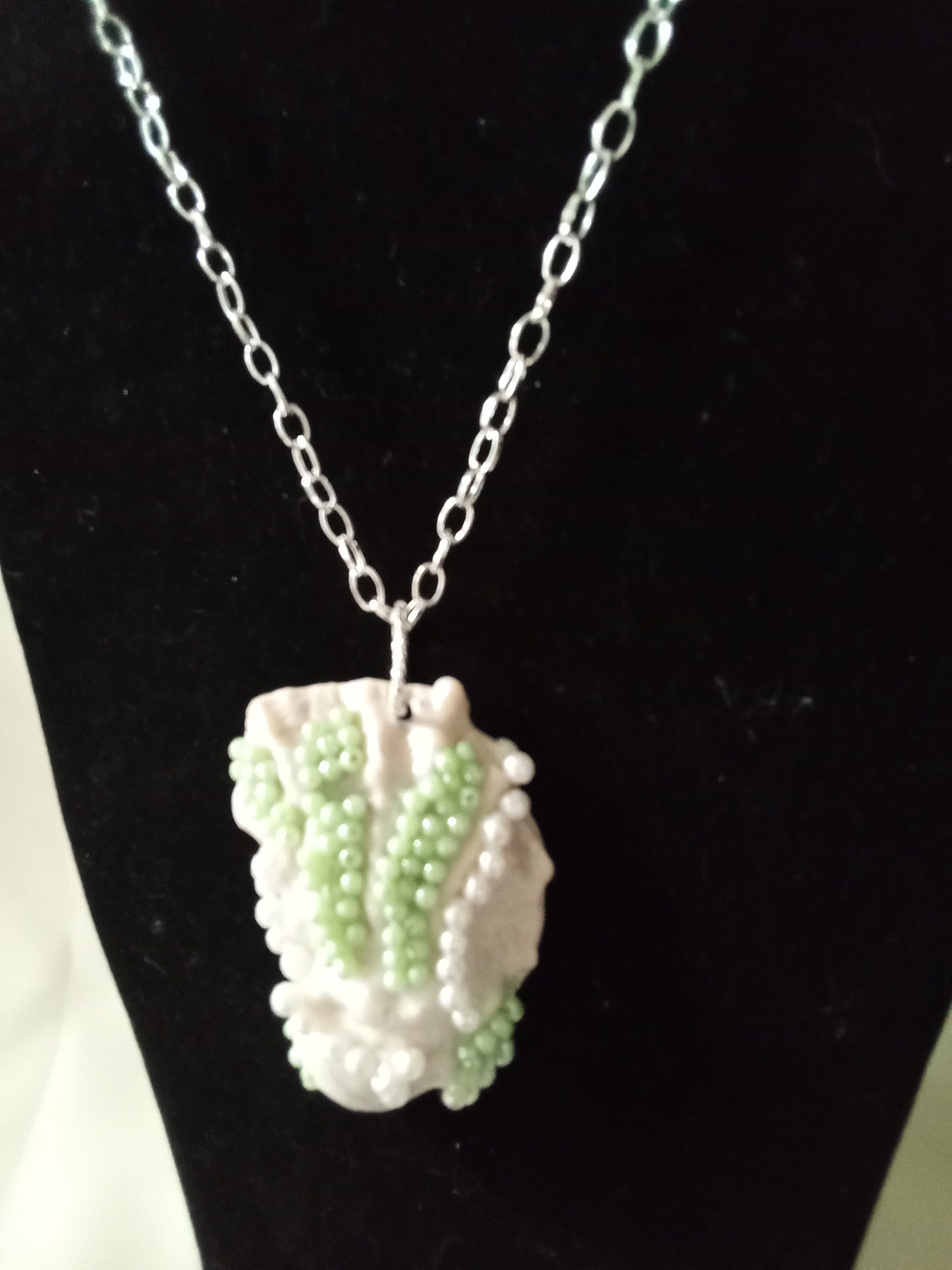 Green and white ornated oyster pendant