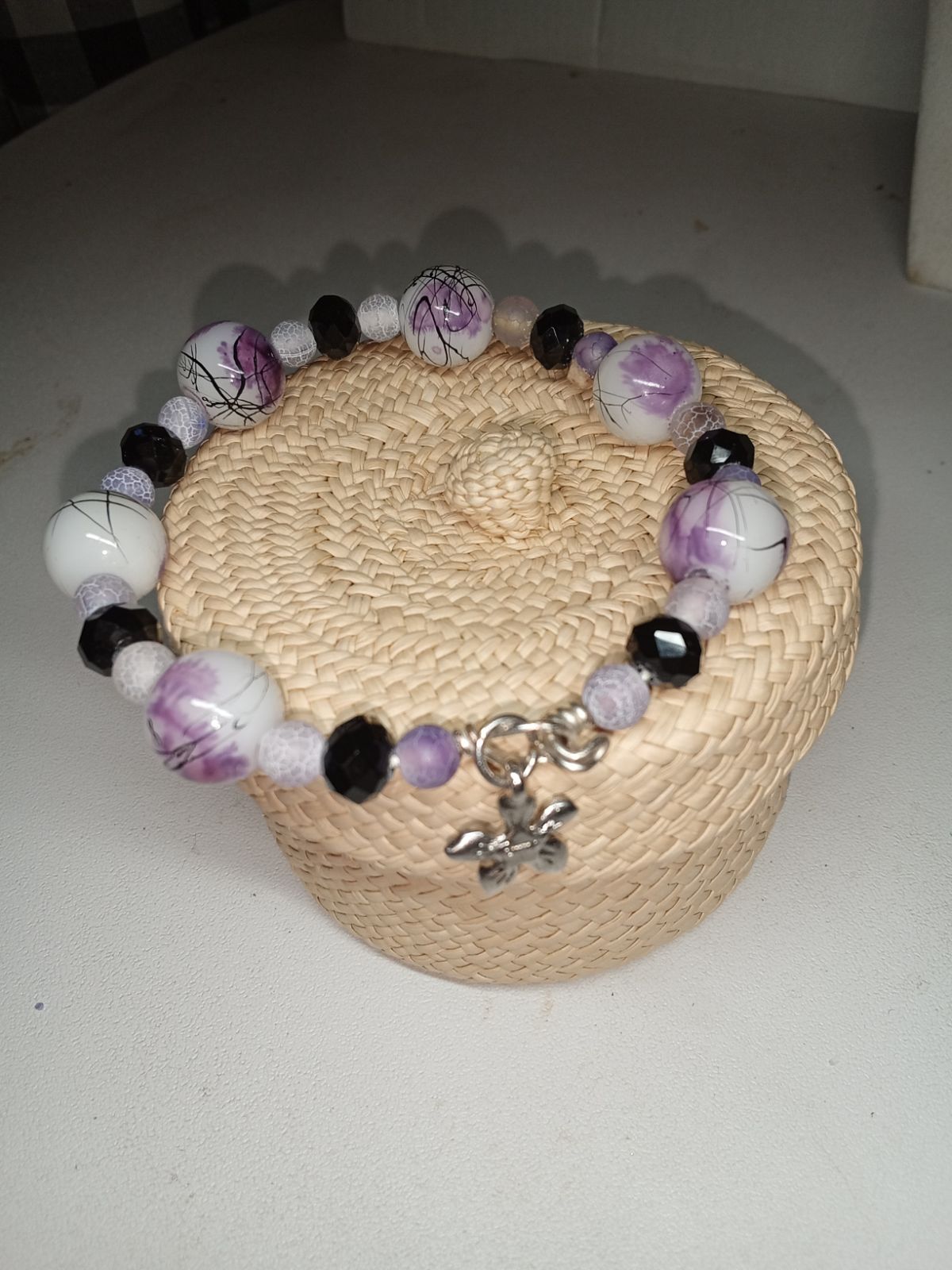 Wire bracelet with interesting ink drizzle look of soft lavender and black on white base.